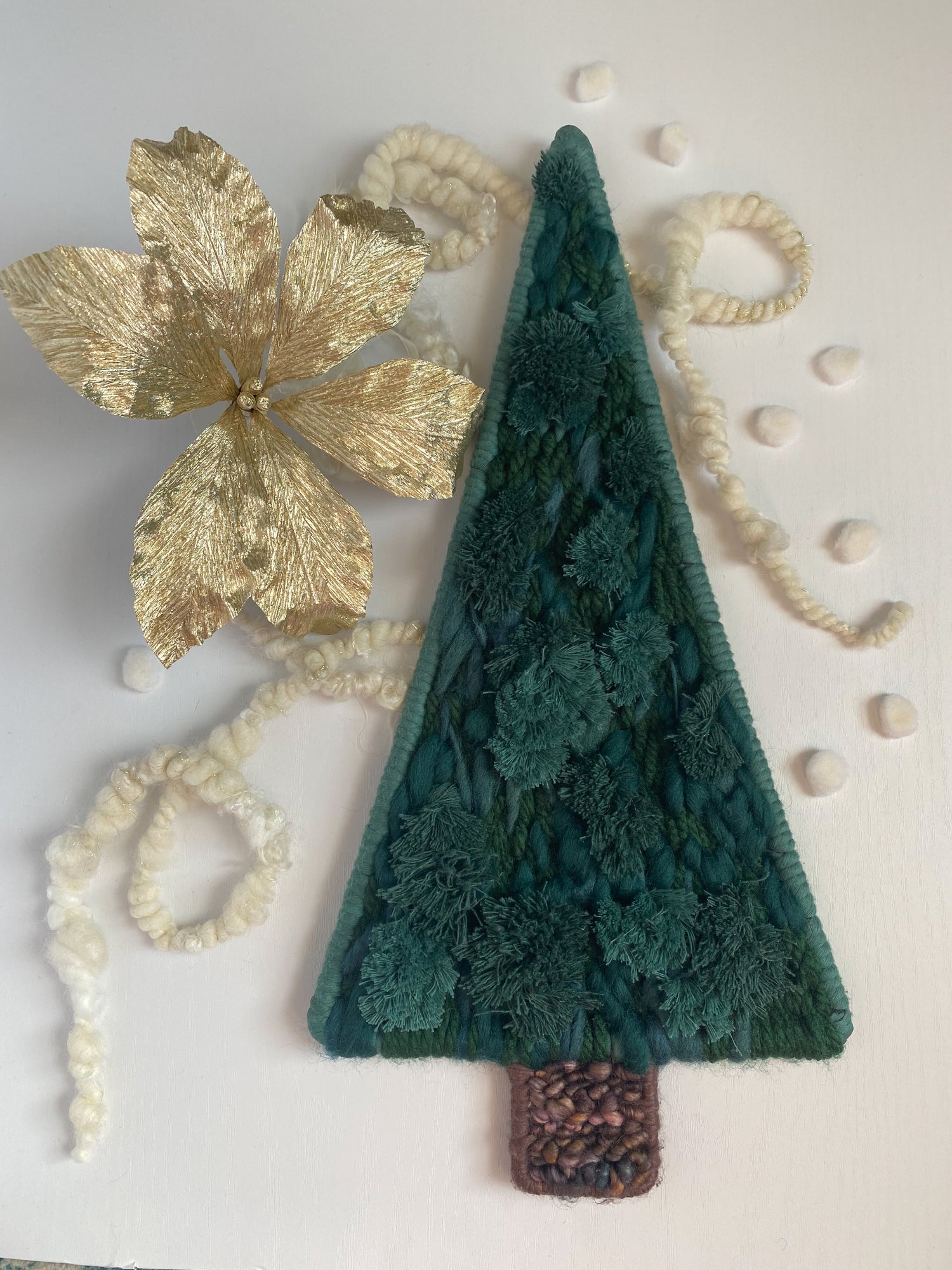 woven green pine tree with gold paper flower and handspun yarn backdrop